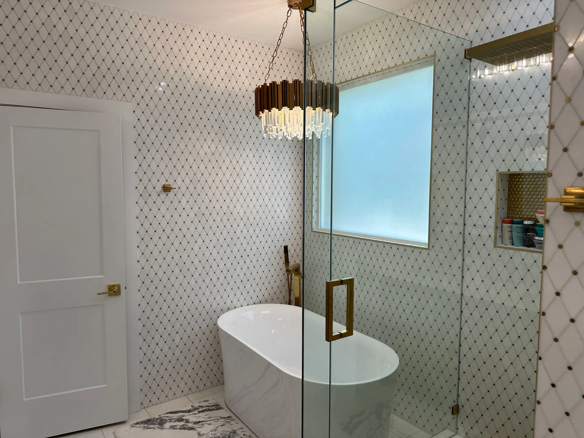 Freestanding tub, frameless glass shower, and pendant chandelier after the remodel